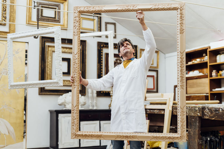 Mature craftsman examining frame at workshop