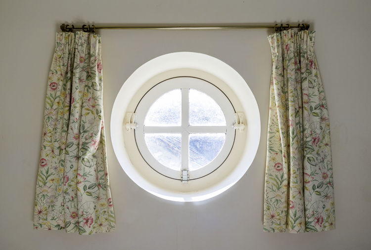 Porthole window and curtain in ship