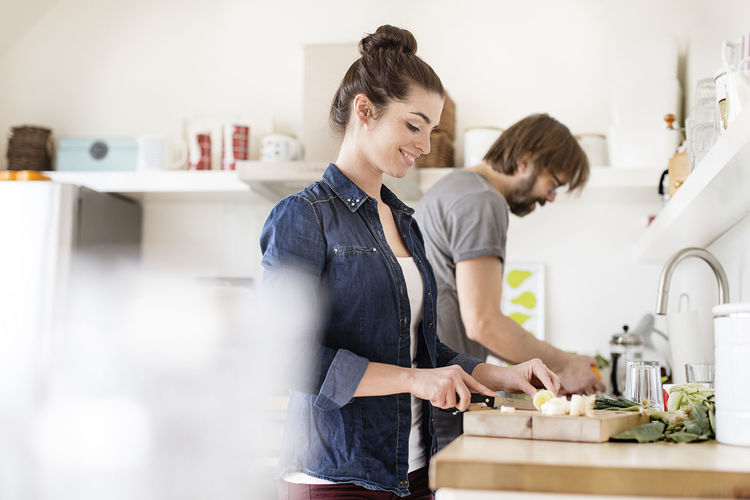 Couple in kitchen preparing food