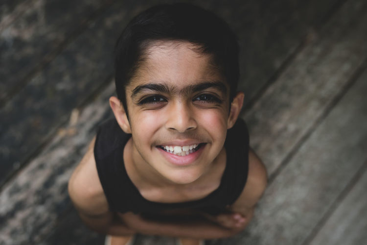 High angle portrait of smiling boy standing outdoors