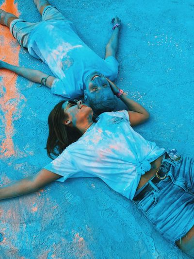 High angle view of young couple lying down on powder paint