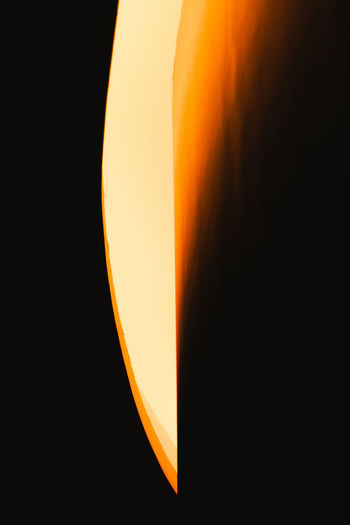 Close-up of illuminated lamp against orange sky
