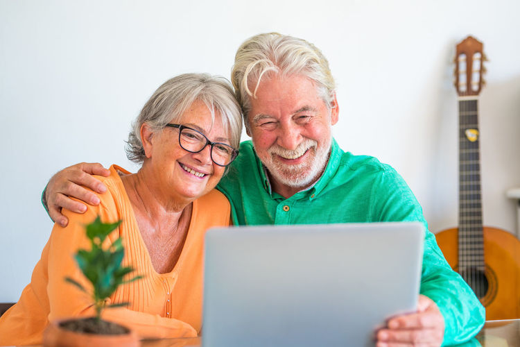 Friends using laptop while sitting on table