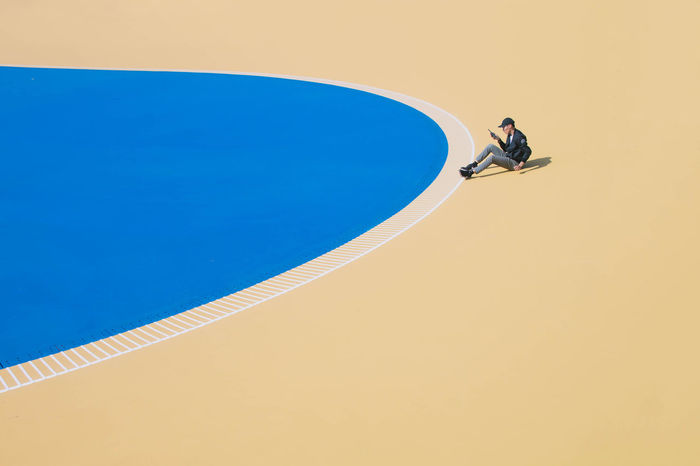 HIGH ANGLE VIEW OF MAN PLAYING IN POOL