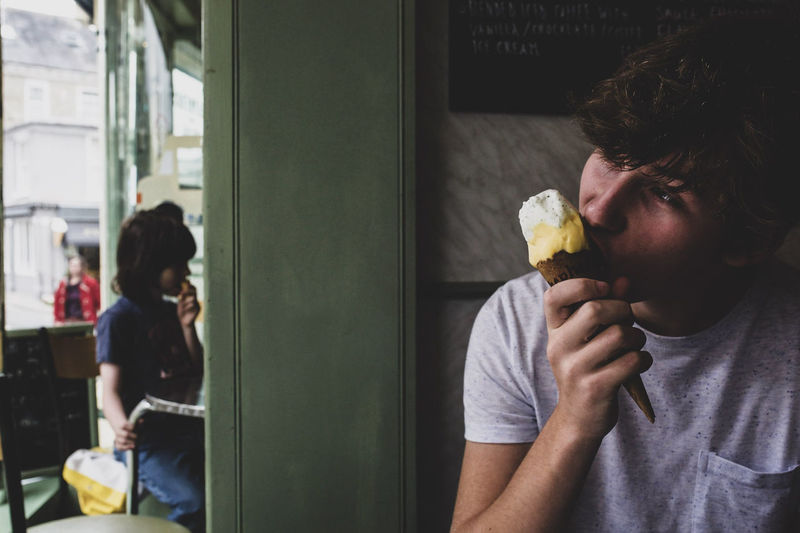 Teenage boy eating ice cream in restaurant