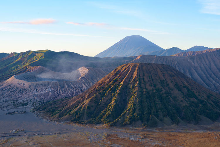 Mount bromo volcano crater eruption, arid landscape against sky, batok mountains, java, indonesia