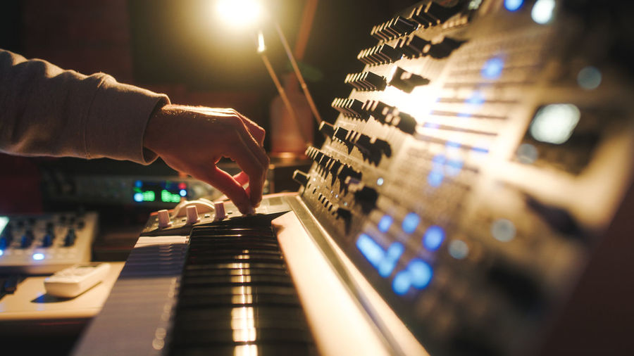 Hands of a man sound engineer are pressing buttons on the console