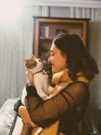 Smiling woman with cat at home