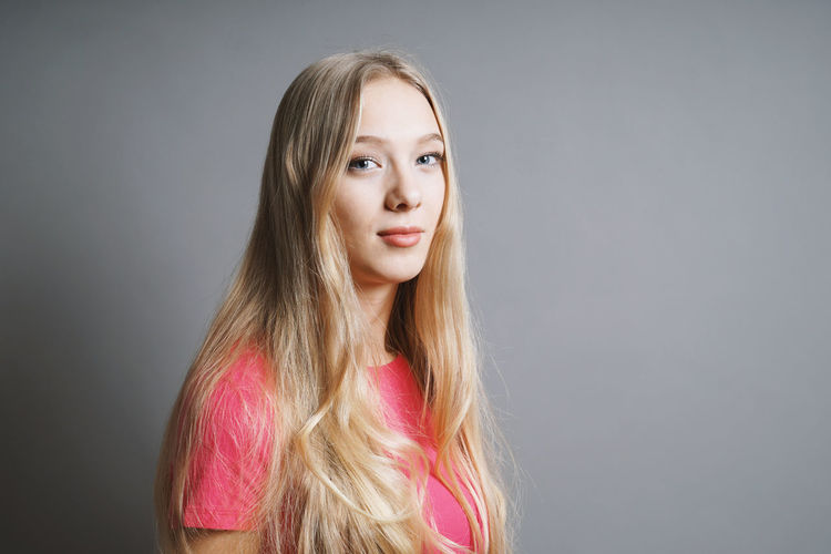 Portrait of a beautiful young woman against gray background