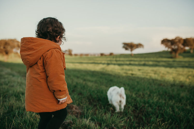 Child walking with dog in a field