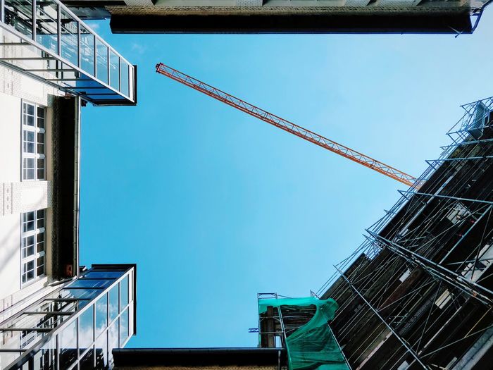 Low angle view of building and construction site against clear sky