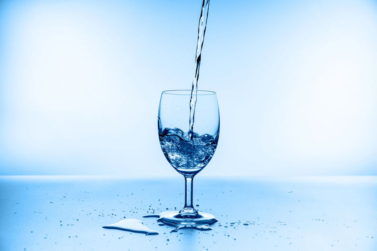 Close-up of wine glass against blue background