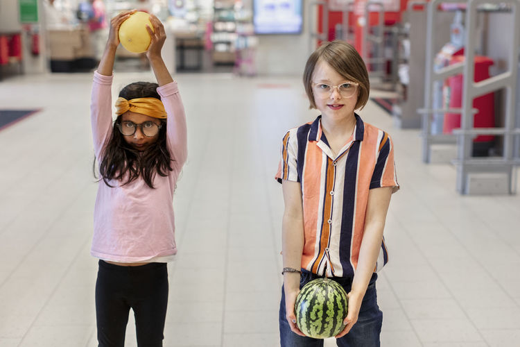Girl in supermarket holding fruits
