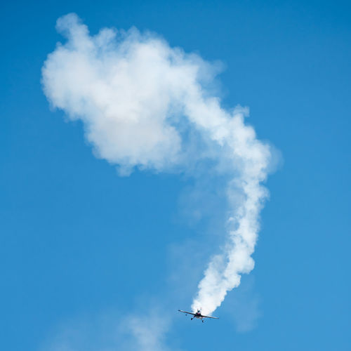 Low angle view of airplane flying against blue sky