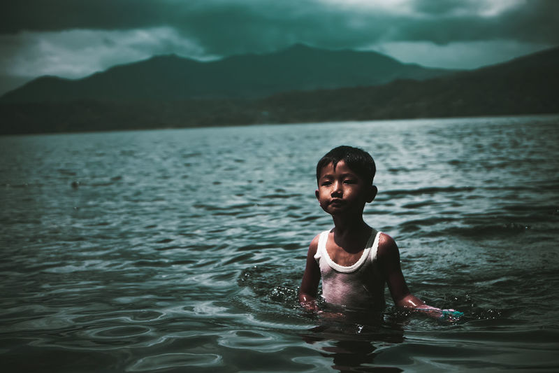 Little boy swimming in the ranau lake, indonesia.