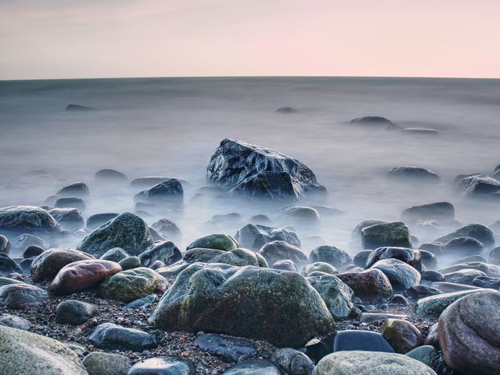 Beautiful seascape sea horizon and norwegian stone coastline, long exposure effect