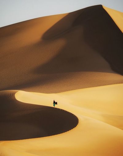 Distant view of woman standing at desert