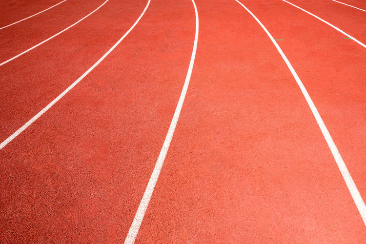 Red running track on athletic stadium