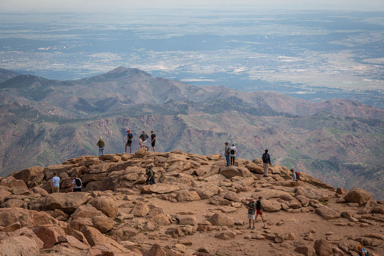 People on rocks against mountain range