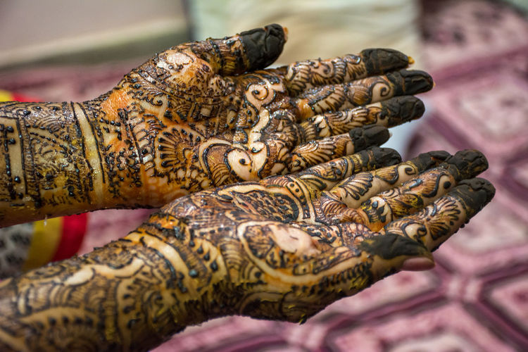 Cropped hands of woman with henna tattoo