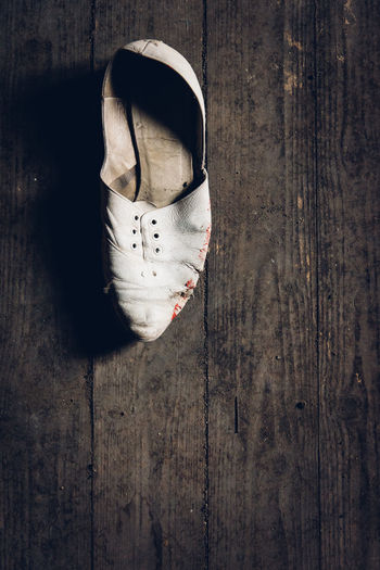 High angle view of abandoned shoe on wooden floor