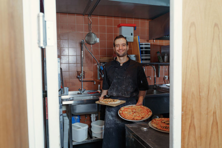 Portrait of man preparing food in kitchen