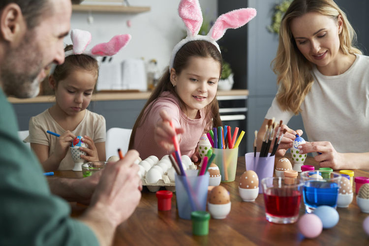 Family preparing easter eggs at home