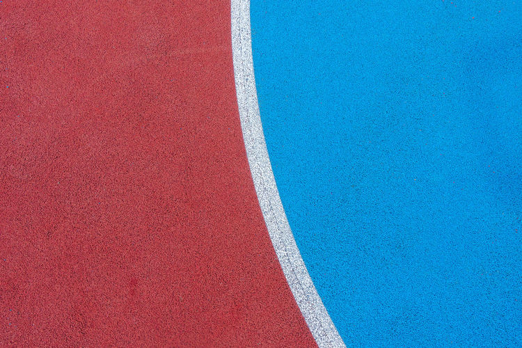 Colorful sports court background. top view to red and blue field rubber ground with  lines outdoors.