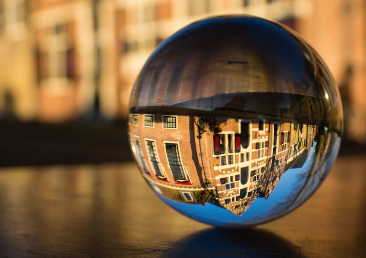 Historical dutch building reflecting upside down in crystal ball 