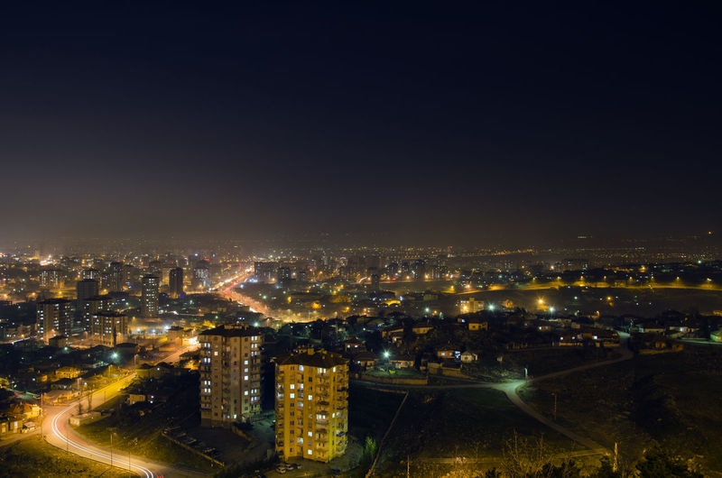 High angle view of illuminated buildings against sky at night