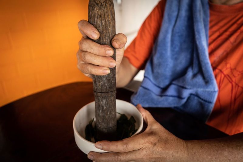 Midsection of man with mortar and pestle