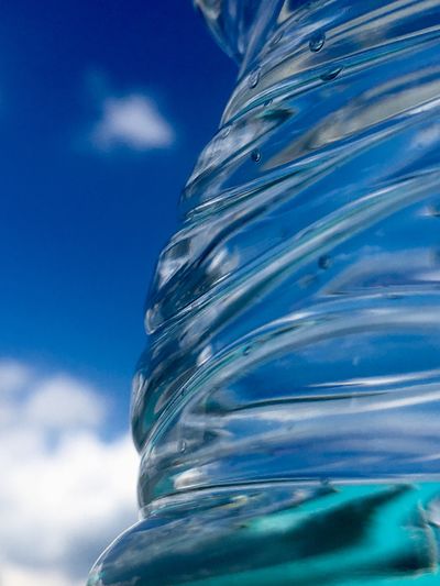 Low angle view of water bottle against blue sky