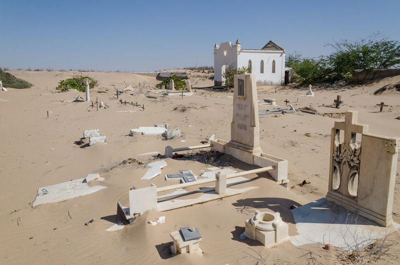 Abandoned cemetery in desert against clear sky