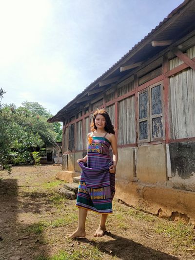 Portrait of woman standing against building