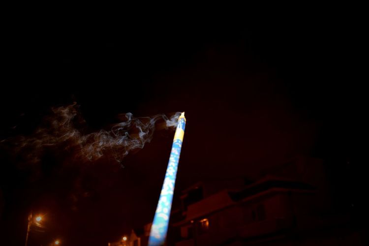 Low angle view of illuminated dark sky