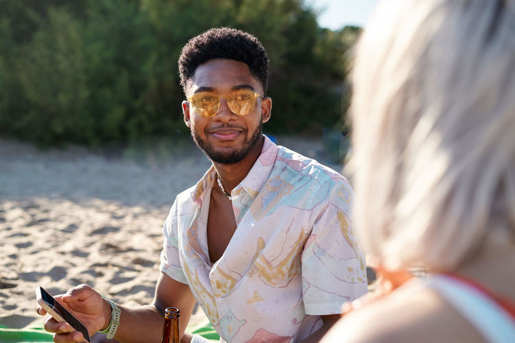 Portrait of smiling young man standing at beach