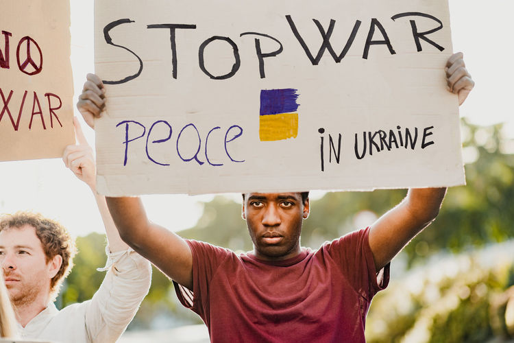 Black man with a banner during the russian war protest.