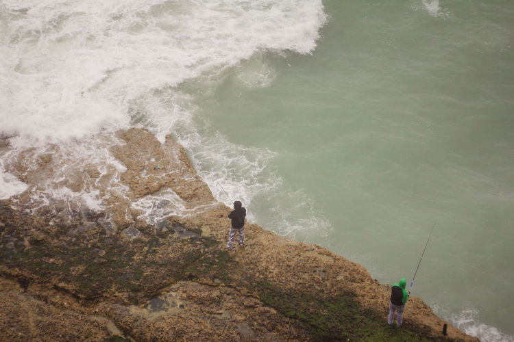 High angle view of men fishing in sea