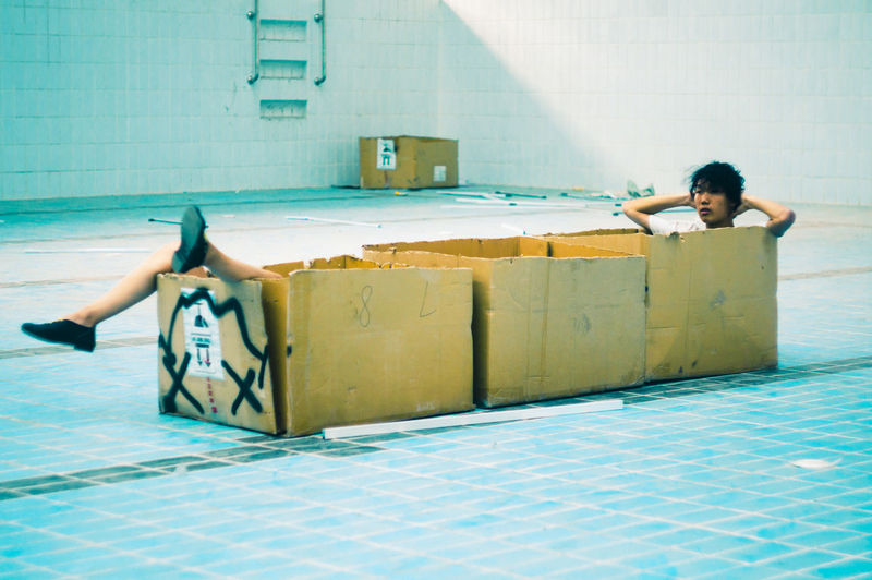 Man sitting in box in swimming pool