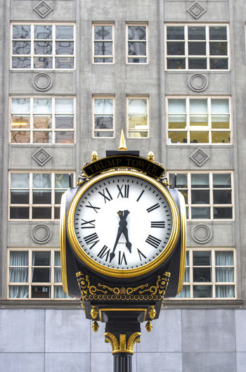 Low angle view of clock against building in city