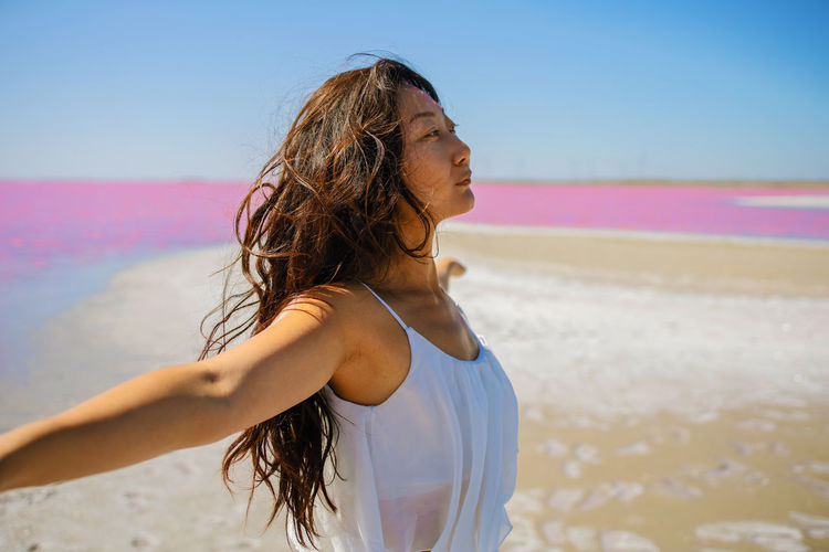 Asian woman enjoying fresh air in pink sea