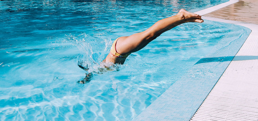 Young Woman Diving Into Pool.