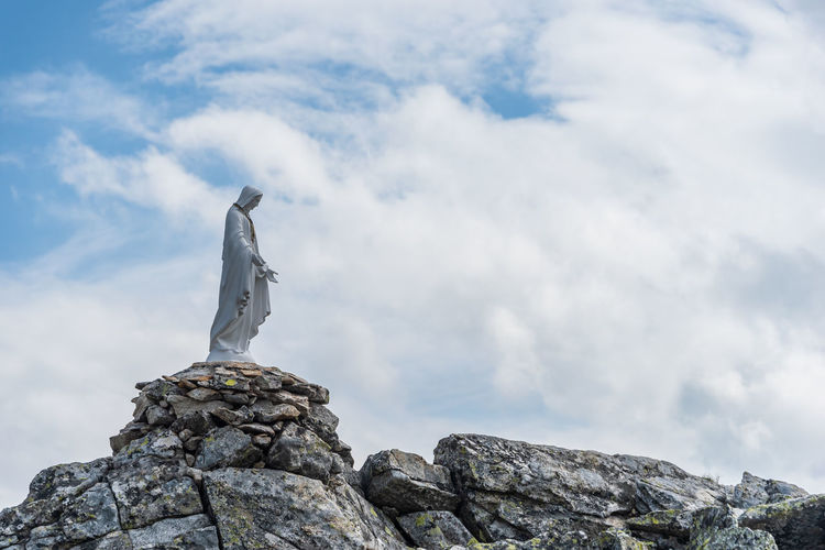 White statue of virgin mary, mother of god, placed on top of the mountain. 