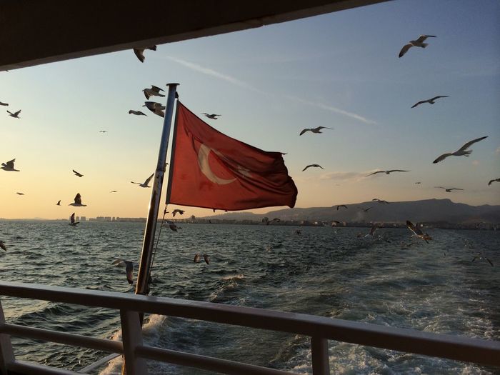Turkish flag on boat in sea during sunset