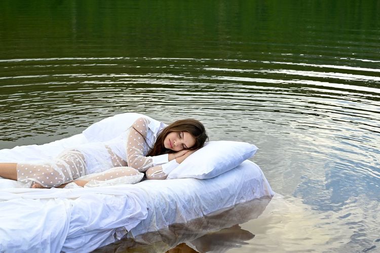 Portrait of woman lying in lake