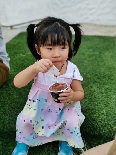 Full length of cute girl holding grass