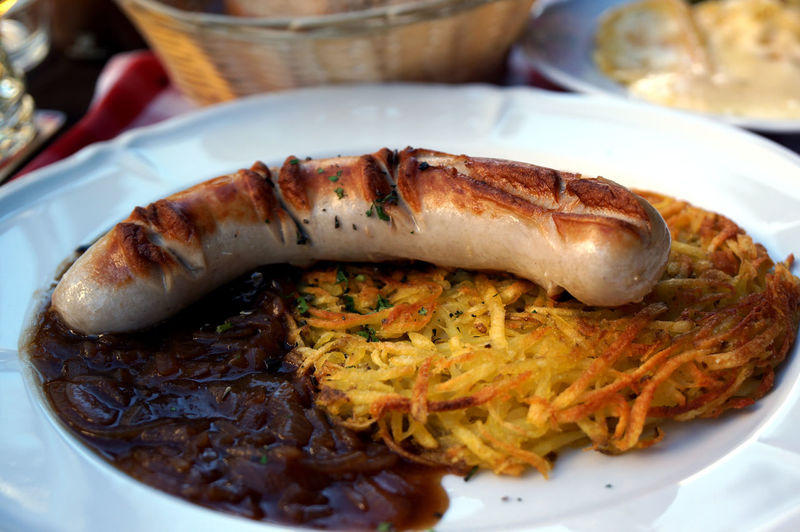 Close-up of veal sausage with rosti in plate