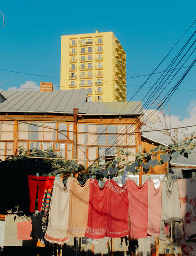 Clothes drying on clothesline outside building against sky