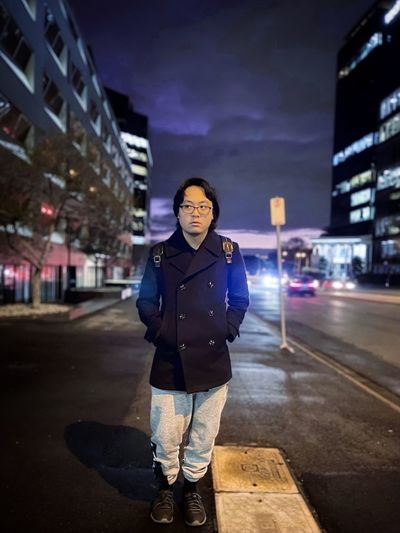 Portrait of young asian man standing in the city.