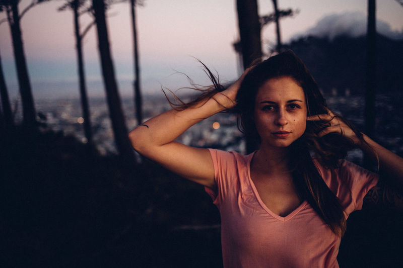 Portrait of woman standing against cityscape